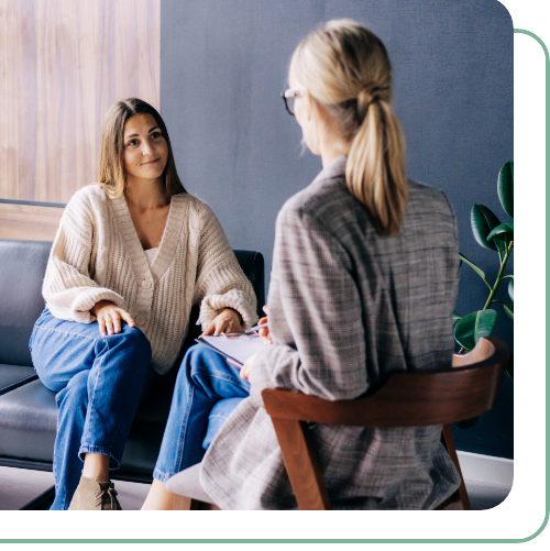 young woman smiling as she speaks with female therapist