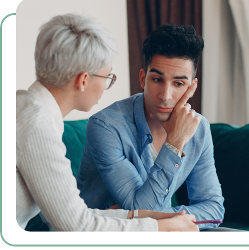 young, worried looking man speaking to older female behavioral health specialist